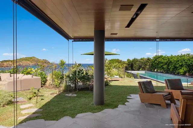 Covered patio with wooden ceiling overlooking pool and ocean at Villa Jangali, Flamands
