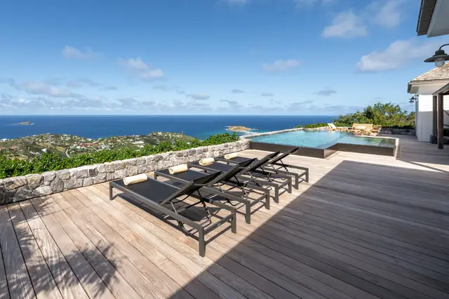 Rectangular pool with lounge chairs and towels overlooking coastal landscape at Villa Ma’O, Vitet