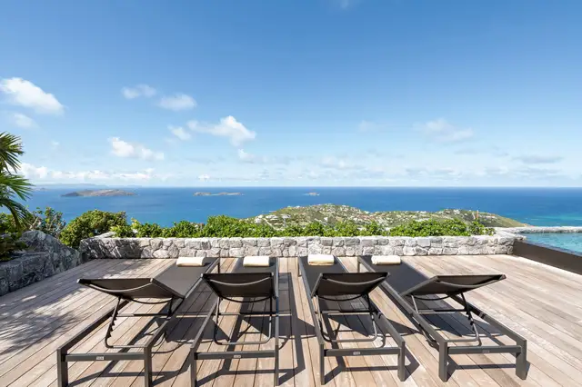 Four lounge chairs on terrace overlooking ocean and islands at Villa Ma’O, Vitet
