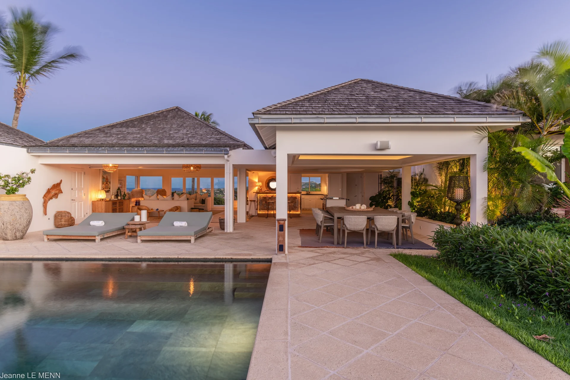 Terrace with dining table and sunbeds beside swimming pool at Villa Poppy, Mont Jean